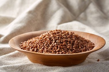 Bir yuvarlak ahşap plaka saf masa örtüsü, üstten görünüm, seçici odak yakın çekim buğday.