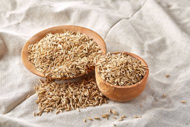 Yulaf kabuğu çıkarılmış tane saf masa örtüsü arka plan, seçici odak, yakın çekim ile iki ahşap kase.