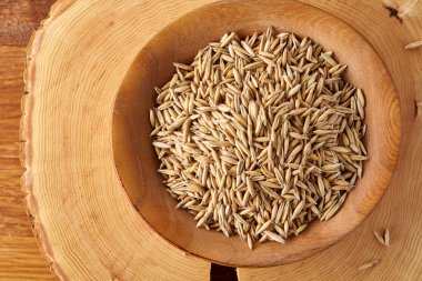 Yulaf kabuğu çıkarılmış tane veya yulaf ani artış ahşap plaka üzerinde ahşap günlük, kopya alanı, üstten görünüm seçici odak