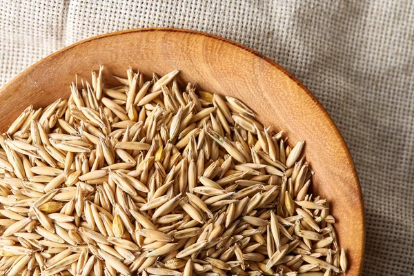 Yulaf kabuğu çıkarılmış tane veya yulaf ani artış ahşap plaka saf masa örtüsü, kopya alanı, üstten görünüm seçici odak üzerinde