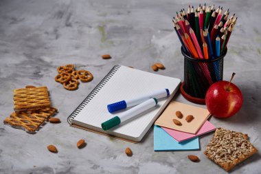 Geri okul kavramı, okul malzemeleri, bisküvi, paket öğle yemeği ve beslenme çantası beyaz yazı tahtası, seçici odak üzerinde.
