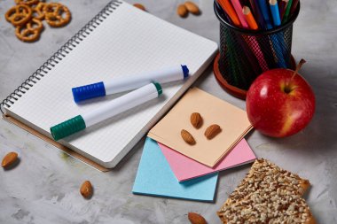 Geri okul kavramı, okul malzemeleri, bisküvi, paket öğle yemeği ve beslenme çantası beyaz yazı tahtası, seçici odak üzerinde.