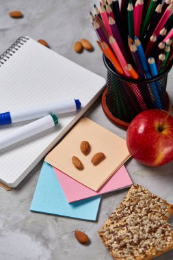 Geri okul kavramı, okul malzemeleri, bisküvi, paket öğle yemeği ve beslenme çantası beyaz yazı tahtası, seçici odak üzerinde.