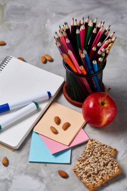 Geri okul kavramı, okul malzemeleri, bisküvi, paket öğle yemeği ve beslenme çantası beyaz yazı tahtası, seçici odak üzerinde.