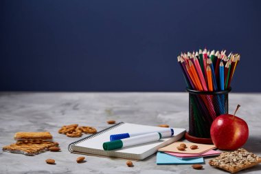 Geri okul kavramı, okul malzemeleri, bisküvi, paket öğle yemeği ve beslenme çantası beyaz yazı tahtası, seçici odak üzerinde.