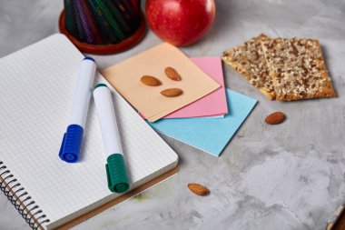 Geri okul kavramı, okul malzemeleri, bisküvi, paket öğle yemeği ve beslenme çantası beyaz yazı tahtası, seçici odak üzerinde.