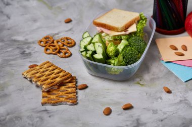 Geri okul kavramı, okul malzemeleri, bisküvi, paket öğle yemeği ve beslenme çantası beyaz yazı tahtası, seçici odak üzerinde.