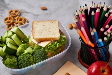 Geri okul kavramı, okul malzemeleri, bisküvi, paket öğle yemeği ve beslenme çantası beyaz yazı tahtası, seçici odak üzerinde.