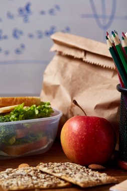 Geri okul kavramı, okul malzemeleri, bisküvi ve beslenme çantası ahşap Resepsiyon, seçici odak, yakın çekim için.