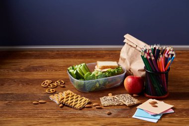 Geri okul kavramı, okul malzemeleri, bisküvi ve beslenme çantası ahşap Resepsiyon, seçici odak, yakın çekim için.