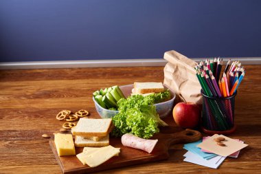 Geri okul kavramı, okul malzemeleri, bisküvi ve beslenme çantası ahşap Resepsiyon, seçici odak, yakın çekim için.