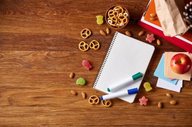 Okul öğle yemeği molası ile sağlıklı öğle yemeği kutusu ve okul malzemeleri ahşap masa, seçici odak kavramı.