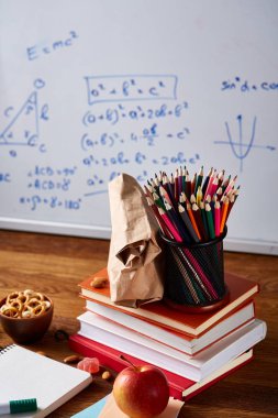 Geri okul kavramı, okul malzemeleri, bisküvi, paket öğle yemeği ve beslenme çantası beyaz yazı tahtası, seçici odak üzerinde.