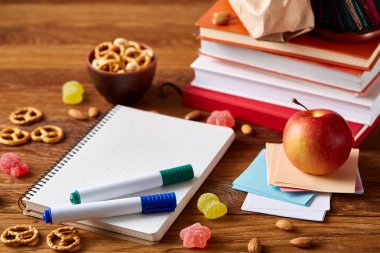 Okul öğle yemeği molası ile sağlıklı öğle yemeği kutusu ve okul malzemeleri ahşap masa, seçici odak kavramı.