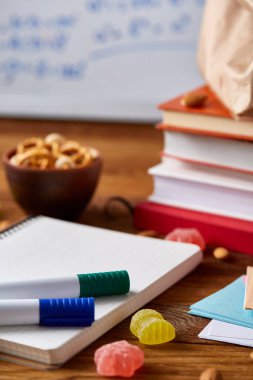 Geri okul kavramı, okul malzemeleri, bisküvi, paket öğle yemeği ve beslenme çantası beyaz yazı tahtası, seçici odak üzerinde.