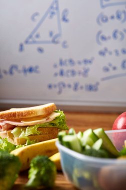 Jambonlu sandviç ahşap arka plan üzerinde scool beslenme çantası hazırlama, yakın çekim.