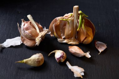 Sarımsak parçaları koyu siyah arka plan üzerine sığ derinliği alan, seçici odak, makro yakın çekim