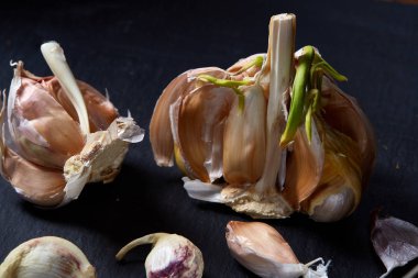 Sarımsak parçaları koyu siyah arka plan üzerine sığ derinliği alan, seçici odak, makro yakın çekim