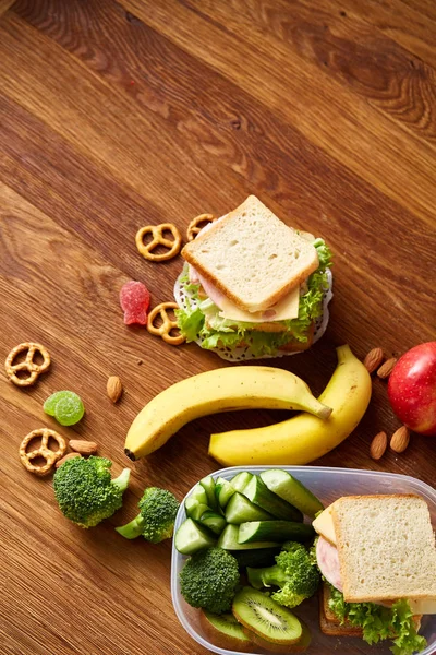 Broodjes ham voorbereiden scool lunchbox op houten achtergrond, close-up. — Stockfoto