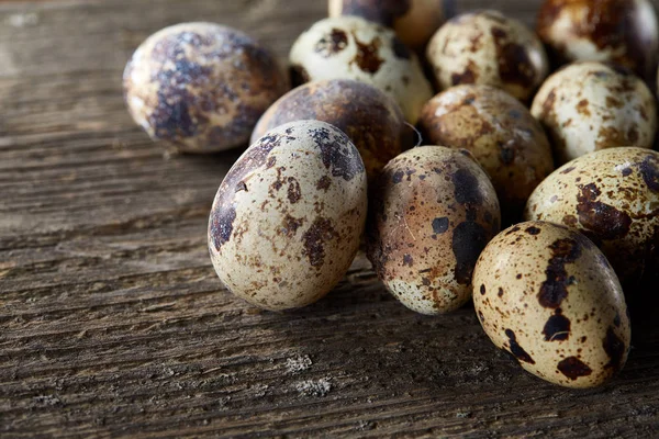 Huevos de codorniz moteados dispuestos sobre el fondo de viejas tablas de madera, con espacio de copia, enfoque selectivo . — Foto de Stock