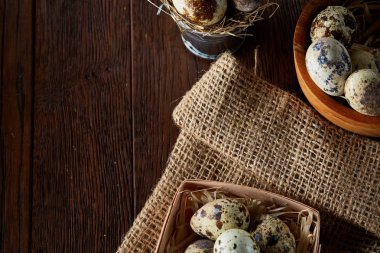 Bıldırcın yumurtası kova, kutu ve ıslak zeminde ahşap arka plan, seçici odak keten bir peçete ile rustik natürmort