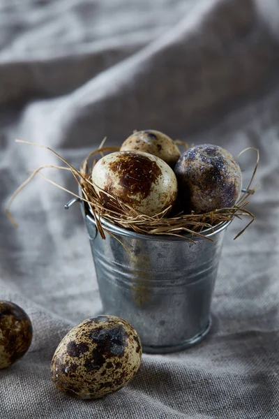 Bıldırcın yumurtası dekoratif bir kova ve bazı yumurta bir saf masa örtüsü, üstten görünüm, yakın çekim