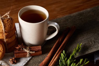 Geleneksel Noel çay bir fincan sıcak çay, kurabiye ve süslemeleri üzerinde ahşap bir masa, seçici odak konseptiyle