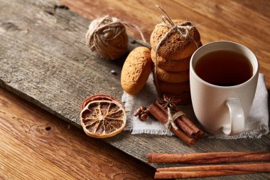 Geleneksel Noel çay bir fincan sıcak çay, kurabiye ve süslemeleri üzerinde ahşap bir masa, seçici odak konseptiyle