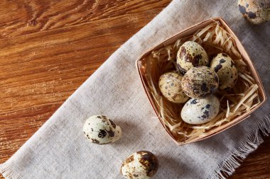 Rustik ahşap masa, yakın çekim, yüksek açılı görünüş, seçici odak kapsayıcısında bıldırcın yumurtası.