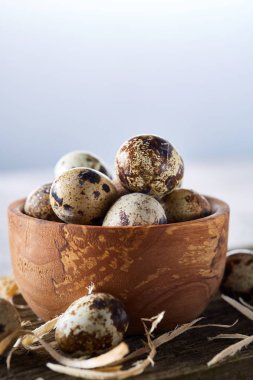 Ahşap kase bıldırcın yumurtası ahşap tahta üzerinde dolu beyaz arka plan, yakın çekim, seçici odak üzerinde.