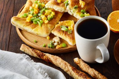 Sabah bir fincan kahve, breadsticks, meyve pasta ve ahşap zemin üzerine portakal konseptiyle.
