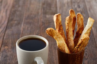 Sabah bir fincan kahve, breadsticks, meyve pasta ve ahşap zemin üzerine portakal konseptiyle.