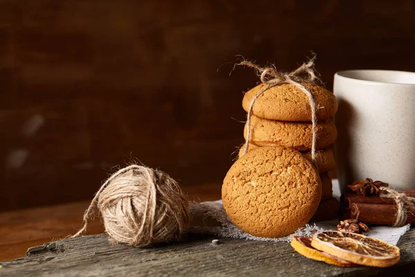 Conceito tradicional de chá de Natal com uma xícara de chá quente, biscoitos e decorações em uma mesa de madeira, foco seletivo — Fotografia de Stock