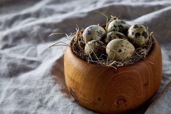 Bodegón rural con cuenco lleno de huevos codorniz, huevos en una servilleta hecha en casa, boj sobre fondo de madera, vista superior — Foto de Stock