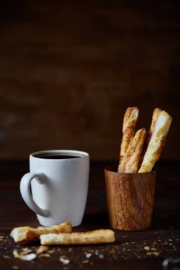 Kahve fincanı ve breadsticks bir eski ahşap arka plan, yakın çekim, seçici odak.