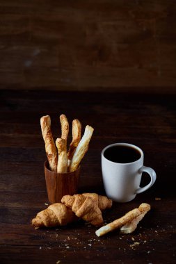 Kahve fincanı ve breadsticks bir eski ahşap arka plan, yakın çekim, seçici odak.