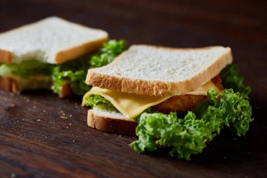 Lezzetli ve taze sandviç kesme tahtası üzerinde bir koyu ahşap arka plan üzerinde yakın çekim