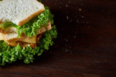 Lezzetli ve taze sandviç kesme tahtası üzerinde bir koyu ahşap arka plan üzerinde yakın çekim