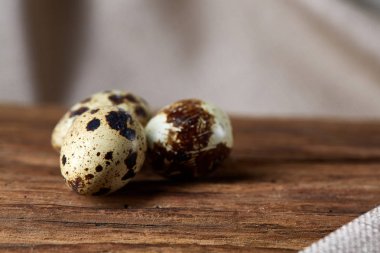 Piramit peçeteye Şimşir dalları ile düzenlenmiş bir ahşap masa, yakın çekim, seçici odak üzerinde bıldırcın yumurtası.