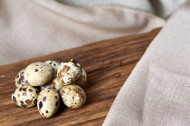 Piramit peçeteye Şimşir dalları ile düzenlenmiş bir ahşap masa, yakın çekim, seçici odak üzerinde bıldırcın yumurtası.