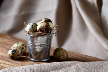 Bıldırcın yumurtası dekoratif bir kova ve bazı yumurta bir saf masa örtüsü, üstten görünüm, yakın çekim