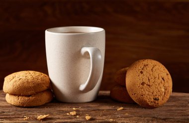 Ahşap ahşap arka plan, üstten görünüm, seçici odak parçası üzerinde çay ve tatlı kurabiye beyaz porselen kupa