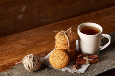 Geleneksel Noel çay bir fincan sıcak çay, kurabiye ve süslemeleri üzerinde ahşap bir masa, seçici odak konseptiyle