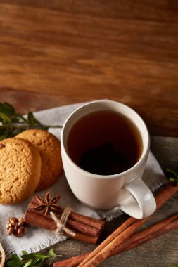 Geleneksel Noel çay bir fincan sıcak çay, kurabiye ve süslemeleri üzerinde ahşap bir masa, seçici odak konseptiyle