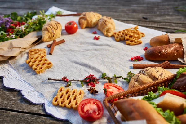 Picnic on a green lawn, pastries and vegetables on a homespun tablecloth, summer season, flat lay, selective focus — Stock Photo, Image