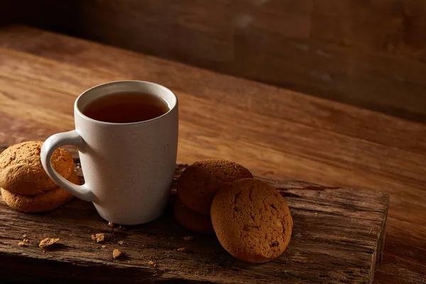 Ahşap ahşap arka plan, üstten görünüm, seçici odak parçası üzerinde çay ve tatlı kurabiye beyaz porselen kupa