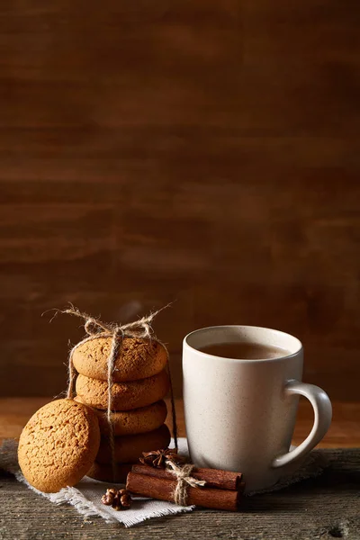 Conceito tradicional de chá de Natal com uma xícara de chá quente, biscoitos e decorações em uma mesa de madeira, foco seletivo — Fotografia de Stock