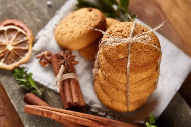 Tanımlama bilgileri, tarçın ve hafif ahşap arka plan üzerinde kurutulmuş portakal yığını ile Noel kompozisyon yakın çekim.
