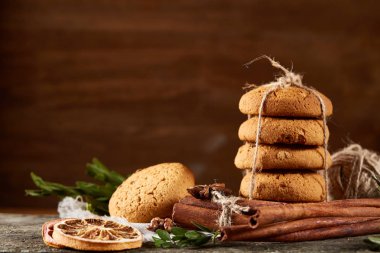 Tanımlama bilgileri, tarçın ve hafif ahşap arka plan üzerinde kurutulmuş portakal yığını ile Noel kompozisyon yakın çekim.