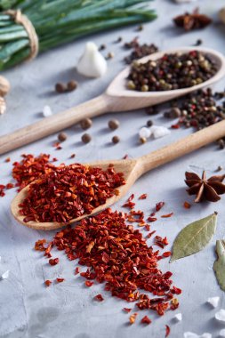 Kırmızı sıcak biber içinde beyaz dokulu arka plan, üstten görünüm, yakın çekim, seçici odak tahta kaşık pul biber.